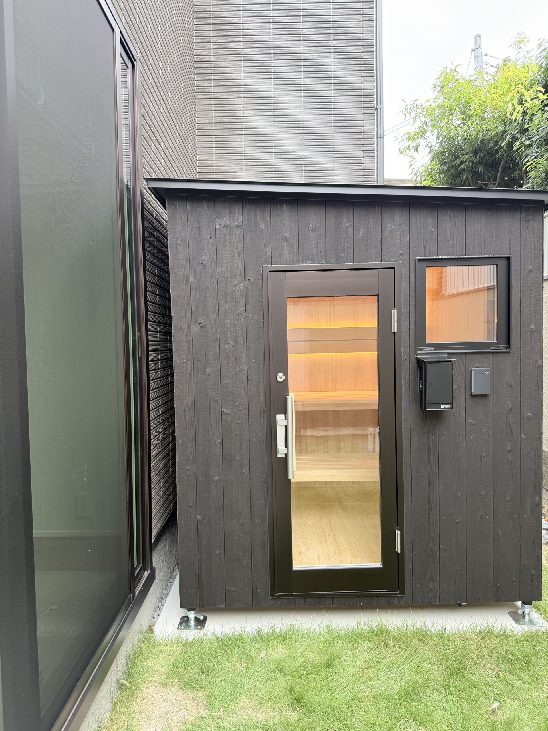 住宅の窓の近くに設置された屋外用サウナ