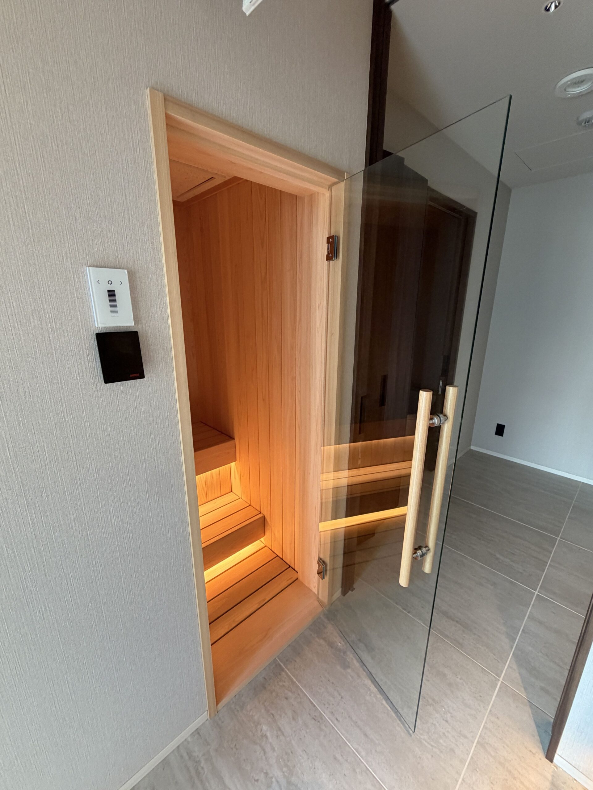 ガラス扉の向こうに見えるサウナ室内